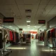 90s global fashion icon store closure with empty racks and clearance signs indicating retail decline