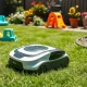 AI lawn mower intelligently navigating around garden obstacles while maintaining perfect grass cutting