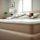 A person sleeping soundly on a bed, showcasing the enhanced comfort provided by an Amazon mattress pad, indicating a restful night's sleep.