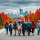 A diverse group of Americans joyfully crossing the US-Canada border, symbolizing the increasing trend of Americans flocking to Canada for new opportunities and a different lifestyle.