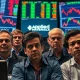 Concerned investors reacting to negative **Applied Materials earnings** news, with stock charts in the background.