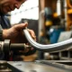 A skilled professional precisely shaping aluminum tubing using a specialized bending machine, demonstrating effective bending aluminum tubing techniques.