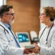 A doctor and patient discussing health information on a tablet, illustrating how Electronic Health Records enhance patient-doctor communication.