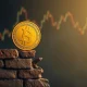 A golden coin teetering on a crumbling wall, representing the anticipated gold price fall from the 'Wall of Worry' as predicted by analysts.