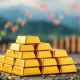 A stack of gleaming gold bars symbolizing the recent drop in gold price due to U.S. tariff plan clarifications.