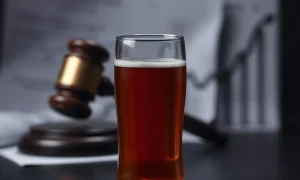 A hard cider bottle and glass symbolizing the recent hard cider company bankruptcy and its financial challenges.