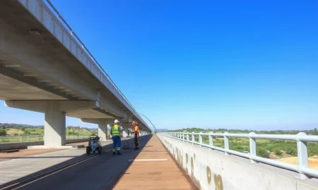 Workers applying advanced infrastructure coatings to a bridge deck, significantly enhancing its durability and ensuring public safety.
