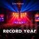 A dynamic concert stage with a spotlight on the Live Nation logo, representing the company's drive for a record year through massive shows.