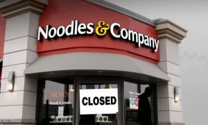 Sign on a closed Noodles & Company restaurant, symbolizing the widespread Noodles & Company closures and leadership changes within the company.