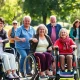 People using various personal mobility aids to achieve independent living outdoors.