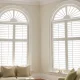 Elegant white plantation shutters enhance a modern living room, offering privacy and light control. This image illustrates the style and functionality of high-quality Plantation Shutters.