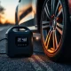 Portable Air Pump inflating car tire during roadside emergency with digital display showing pressure readings