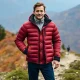 An adventurer enjoys the warmth of their REI down jacket on a brisk mountain trail, highlighting the jacket's comfort and utility.