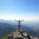 A person stands at a mountain peak, symbolizing the financial freedom to retire at 61.