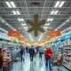 A supermarket aisle with shoppers, illustrating the tangible Tariffs Impact on everyday consumer goods and purchasing power.