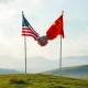 Illustrates the delicate balance of the **US-China trade truce**, showing flags and economic symbols amidst tariff discussions.