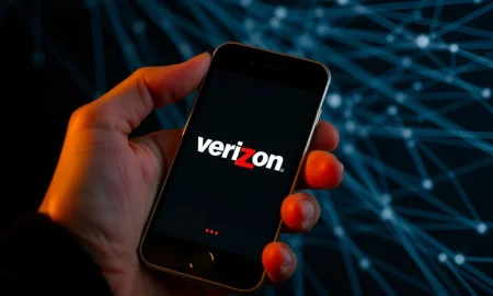 A person looking concerned at their phone, representing the impact of Verizon customer perk discontinuation on phone plan users.