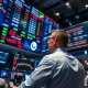 Analyst monitoring consumer inflation data on multiple financial screens during market hours