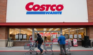 Costco price reduction announcement showing membership card with lowered pricing