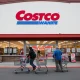 Costco price reduction announcement showing membership card with lowered pricing