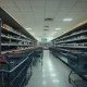 Empty grocery store showing grocery chains closing locations with abandoned shopping carts and dim lighting