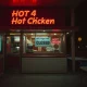 Closed hot chicken chain restaurant with empty dining area and darkened signage