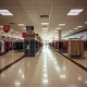 Empty department store showing mall anchors closing with vacant racks and clearance signage