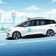 Autonomous robotaxi navigating urban environment with airport backdrop representing future mobility transformation