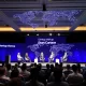 Silicon Valley startups debate panel at tech conference with global map background