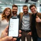 Successful social app founders celebrating their pivot strategy achievement with mobile interface