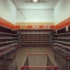 Empty sporting goods retailer store with closed signs and clearance banners indicating massive shutdown