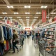 Shoppers enthusiastically browse merchandise in a bustling discount retail store, reflecting robust TJX earnings and strong consumer demand for value.