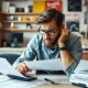 Small business owner analyzing VAT registration threshold changes with financial documents