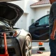 Person performing essential car maintenance tasks including tire pressure check and fluid inspection